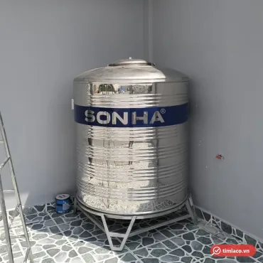 Bồn inox Sơn Hà dạng đứng trên chân đế inox đặt ở góc sân thượng, dải xanh in chữ SONHA (ảnh minh hoạ dòng hàng)