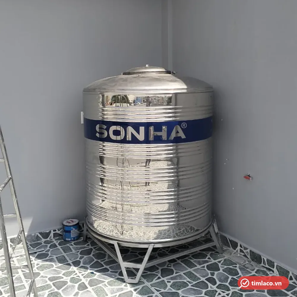 Bồn inox Sơn Hà dạng đứng trên chân đế inox đặt ở góc sân thượng, dải xanh in chữ SONHA (ảnh minh hoạ dòng hàng)