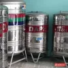 Bồn nước inox Dapha 500 lít đứng, băng đỏ chữ DAPHA và nhãn 500L, xếp cùng các bồn Dapha khác tại cửa hàng