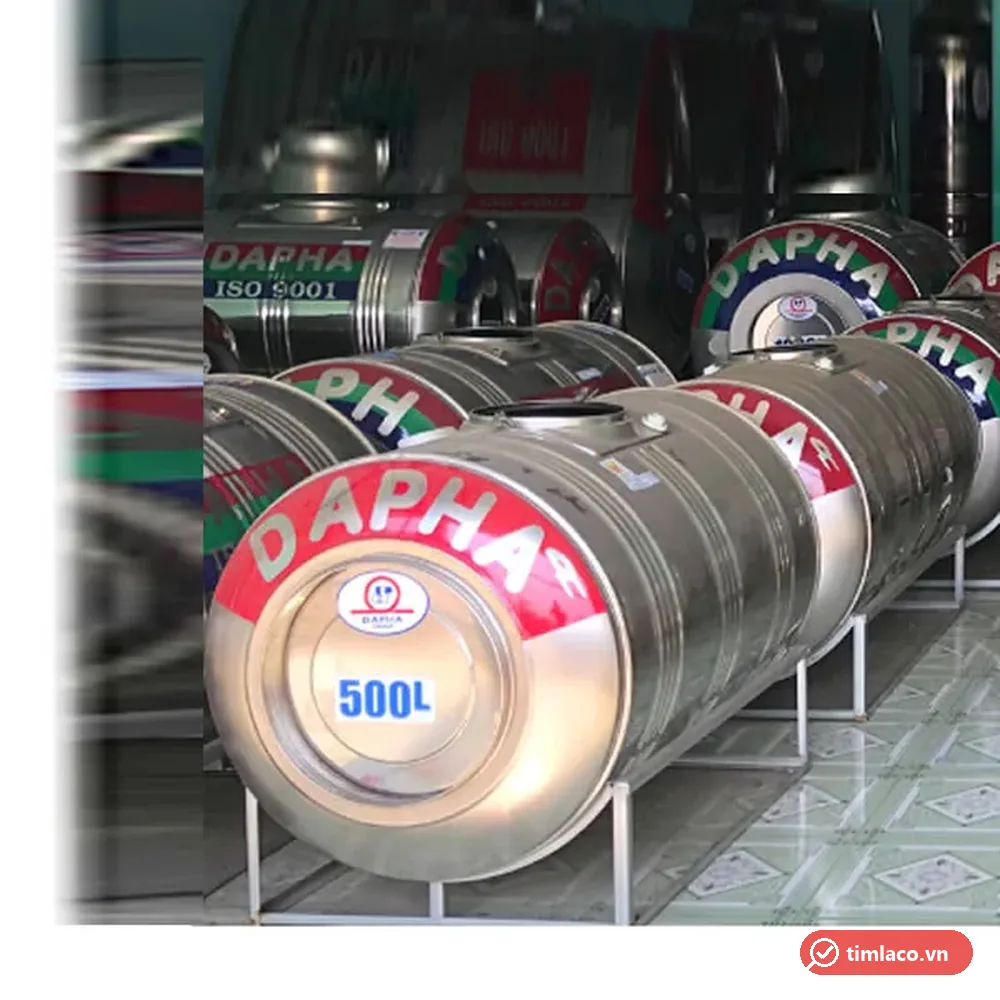 Bồn nước inox Dapha 500 lít ngang trên khung chân, nắp đỏ chữ DAPHA và nhãn 500L, xếp hàng tại cửa hàng