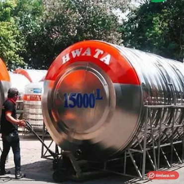 Bồn nước inox Hwata nằm ngang cỡ lớn trên khung chân, đầu bồn sơn đỏ chữ HWATA, đang được kéo ra bãi (ảnh minh hoạ dòng hàng)