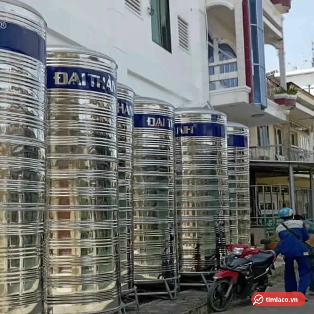 Dãy bồn nước inox Đại Thành kiểu đứng đai xanh đặt cạnh nhà phố (ảnh minh hoạ dòng hàng)