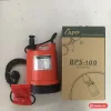 Máy bơm chìm mini APP BPS-100 thân nhựa màu cam, tem BPS-100 trên thân, cạnh hộp máy BPS-100 Portable Pump