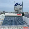 Máy nước nóng năng lượng mặt trời Ariston 300 lít, 28 ống chân không, lắp trên sân thượng, phía sau là bồn nước inox